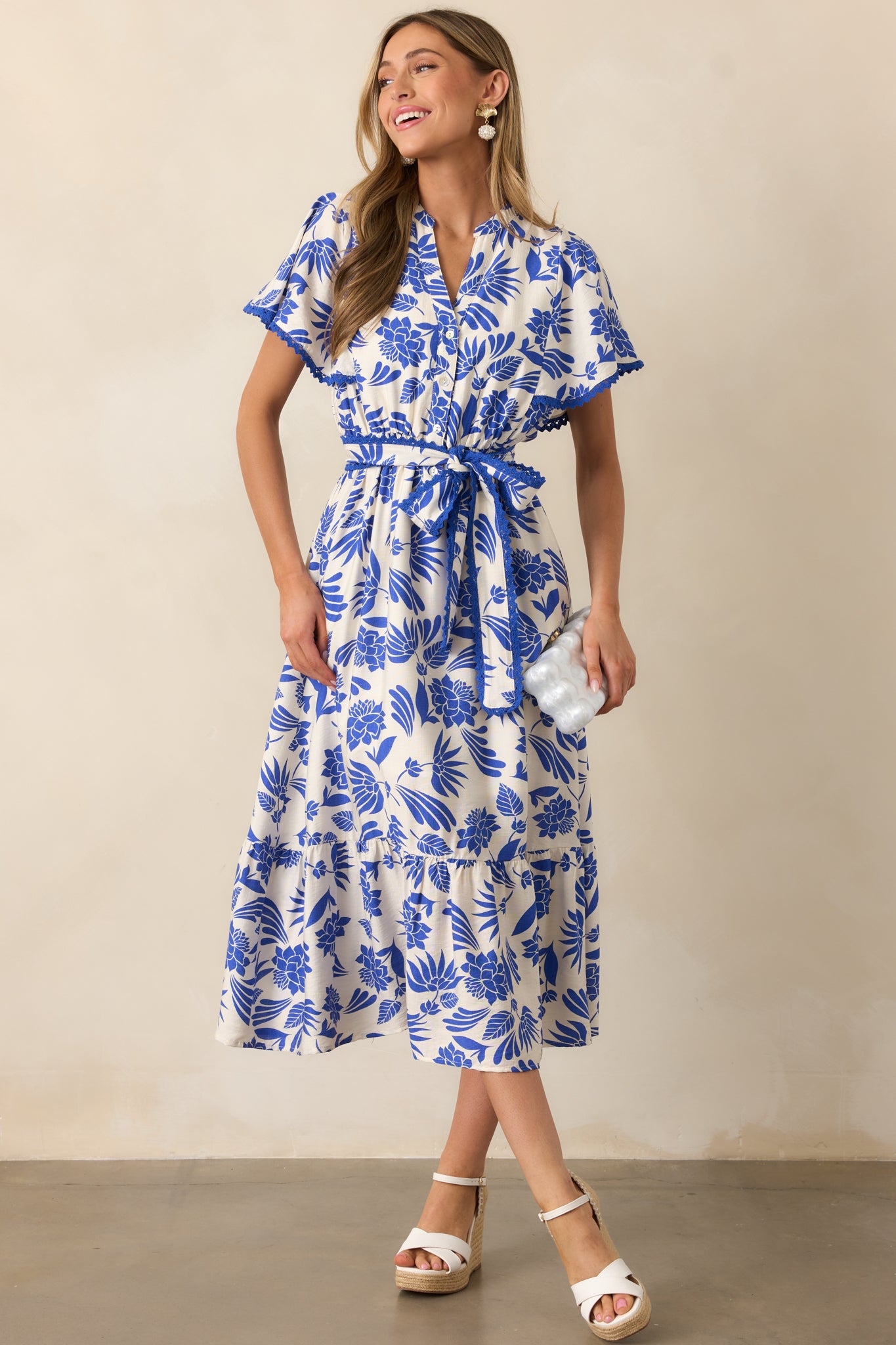 Blue midi dress with a V-neckline, button front top, and a tiered skirt, creating a stylish, flowy silhouette.