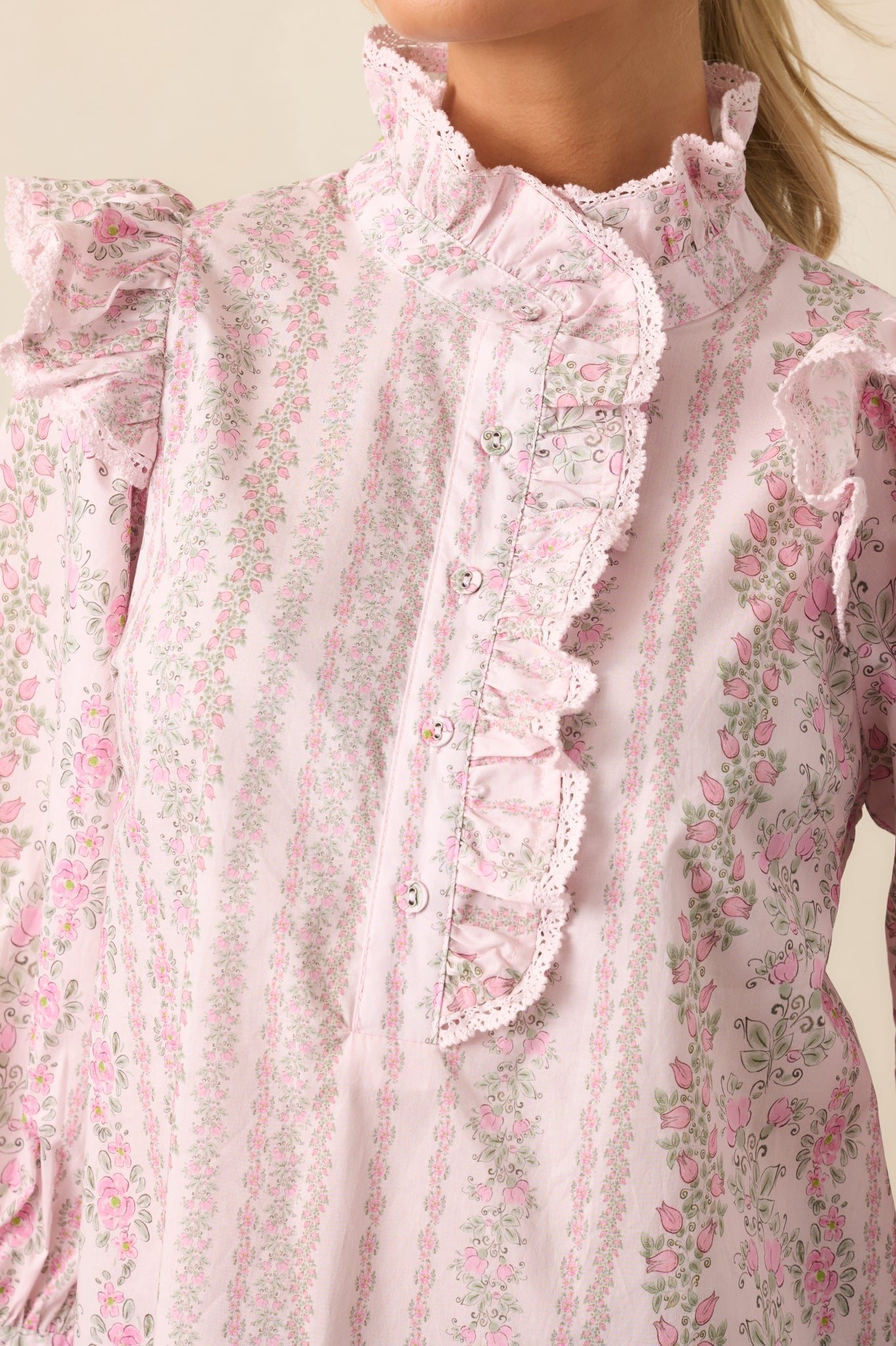 An extreme close-up focusing on the stitching, small buttons, and intricate pink floral pattern.