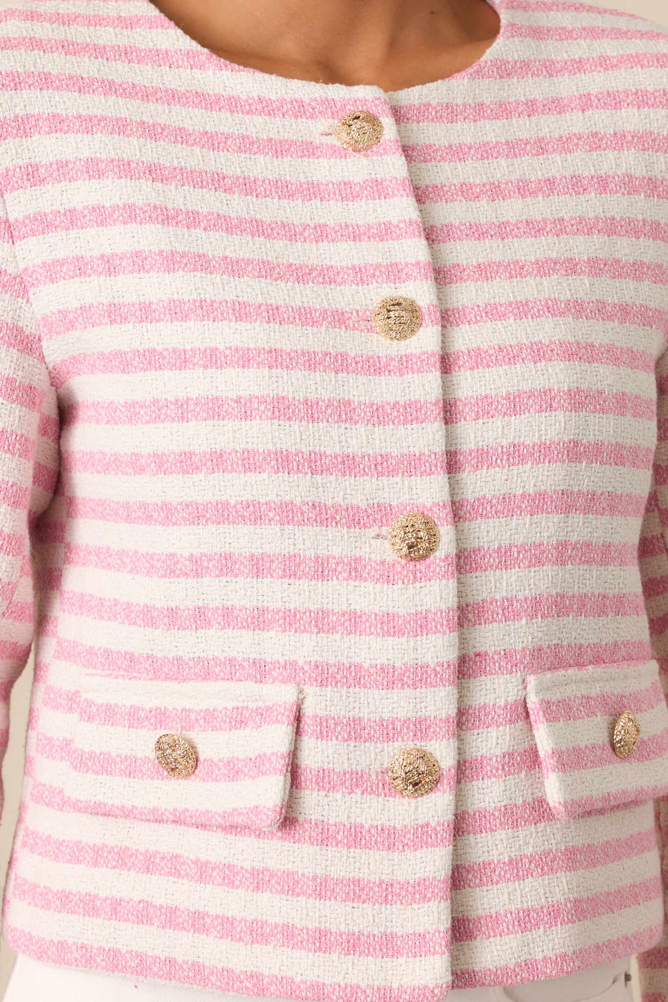 A detailed view of the jacket's gold embellished buttons and the striped fabric, focusing on the intricate design.