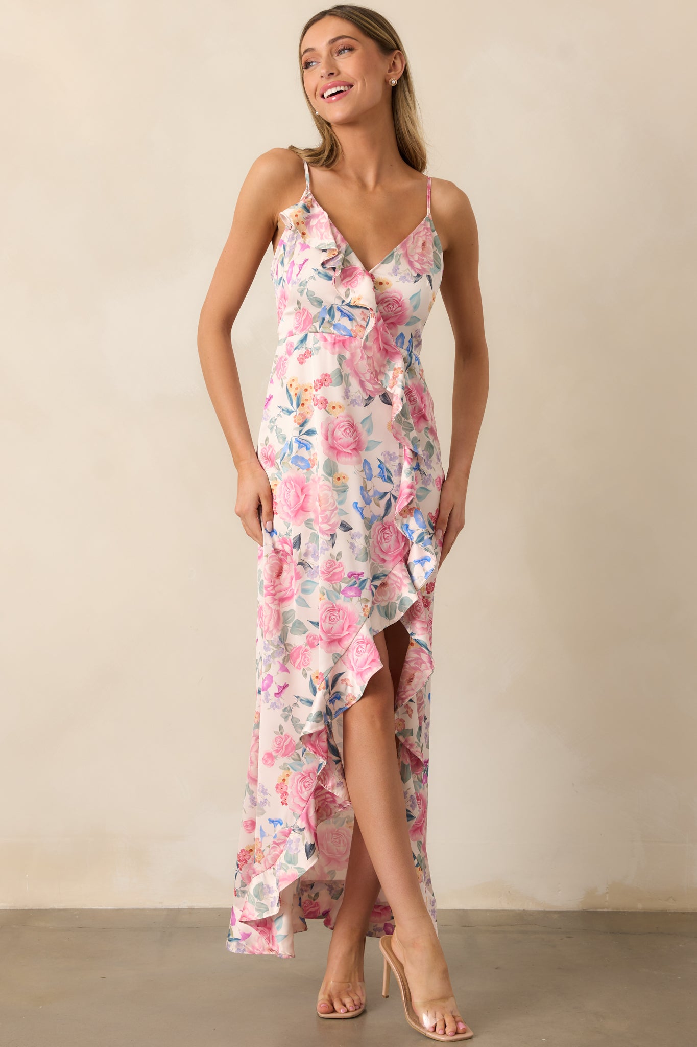 A beautiful pink multi maxi dress with adjustable spaghetti straps, a slit, and delicate ruffles running down the front for an effortless look