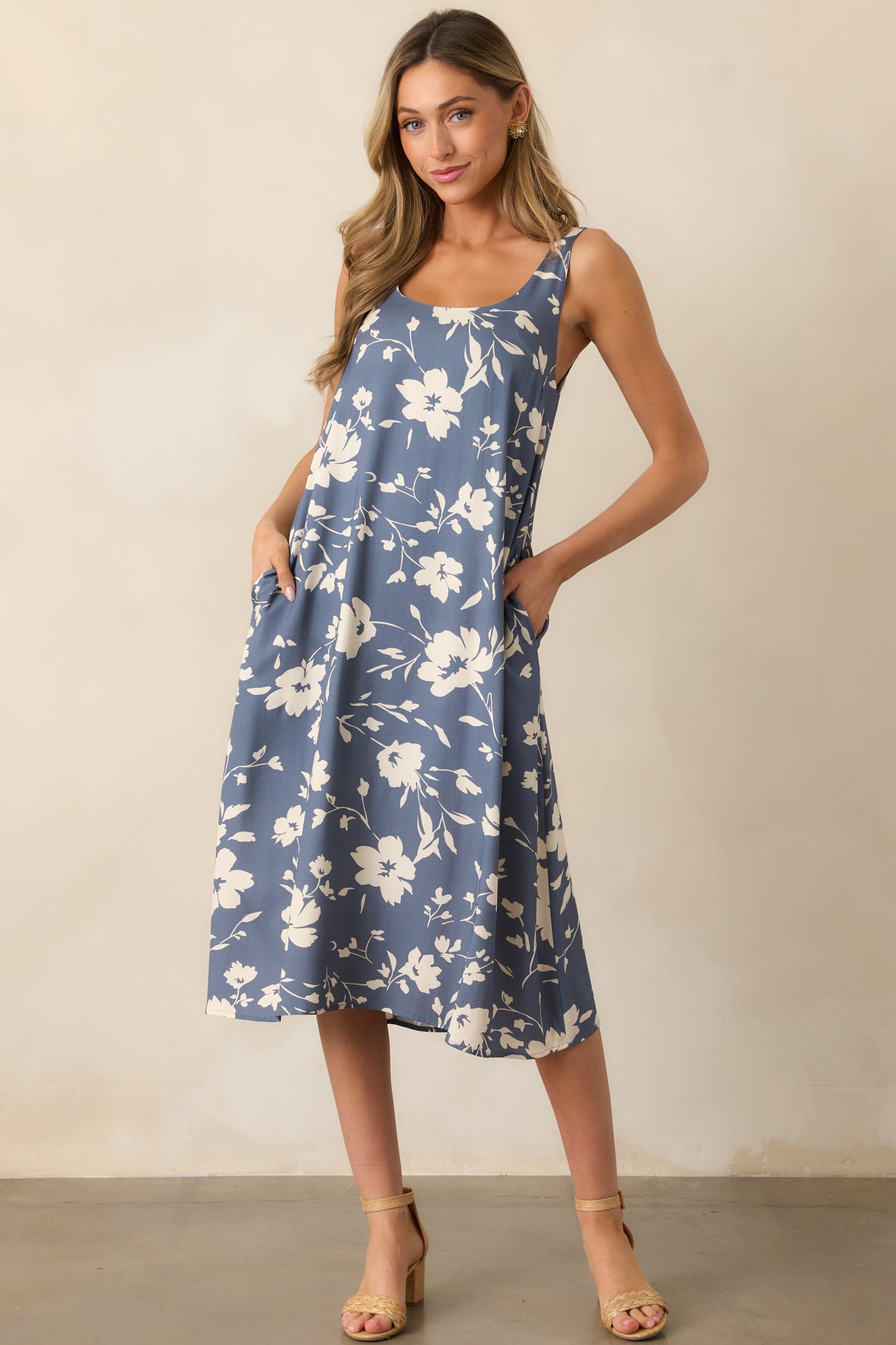 This dusty blue dress features a rounded neckline, with a white floral design adding a touch of elegance, paired with a relaxed fit and a side slit for ease of movement.