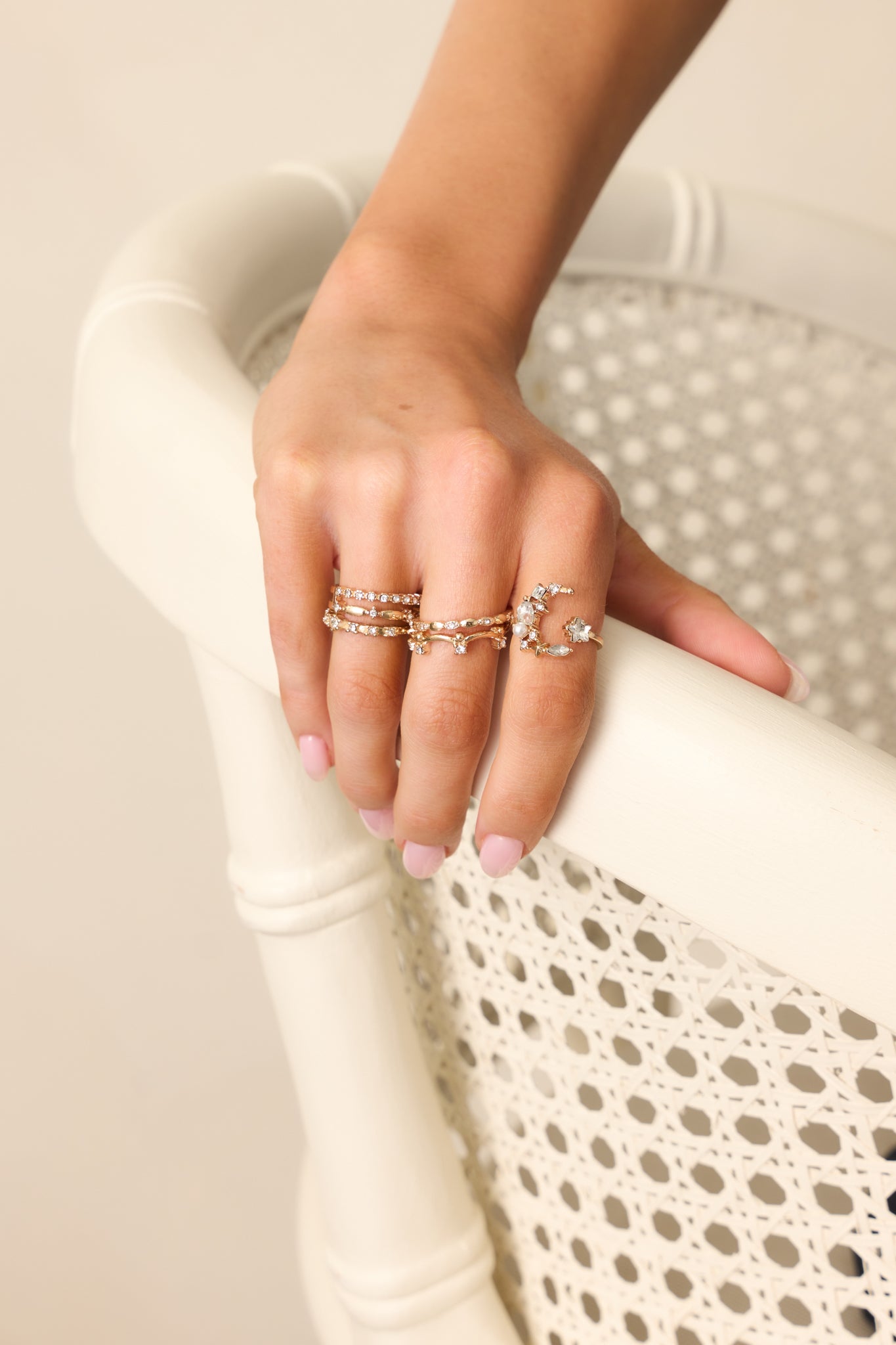 Focused shot of the gold and rhinestone rings, highlighting the intricate designs including the moon & star ring, textured ring, and two star-themed rings, all sparkling with rhinestones.