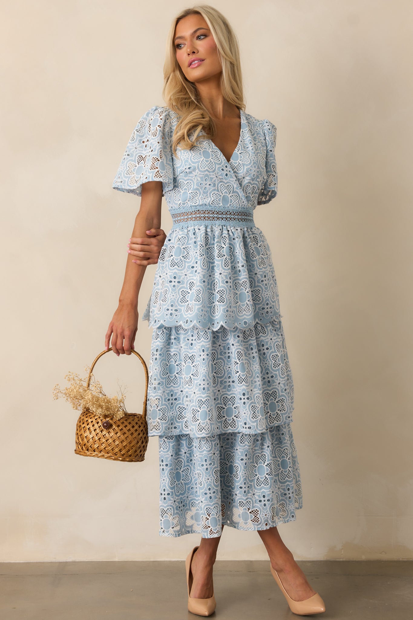 A blue dress with a flowing three-tiered skirt and a ladder trim waistline, creating a breezy and elegant look.