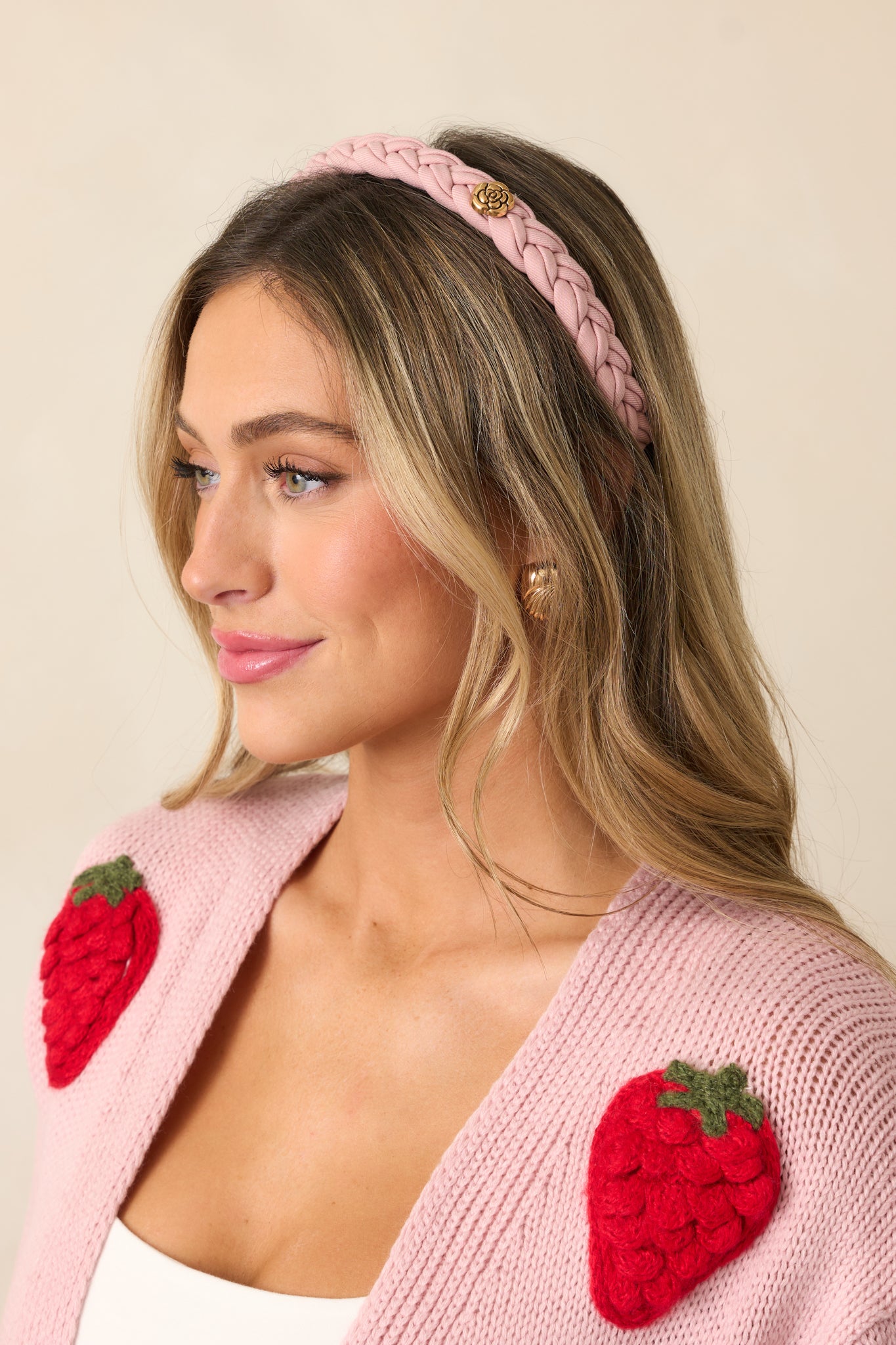 A view of the dusty pink headband, highlighting its thin band and delicate braided cloth design.