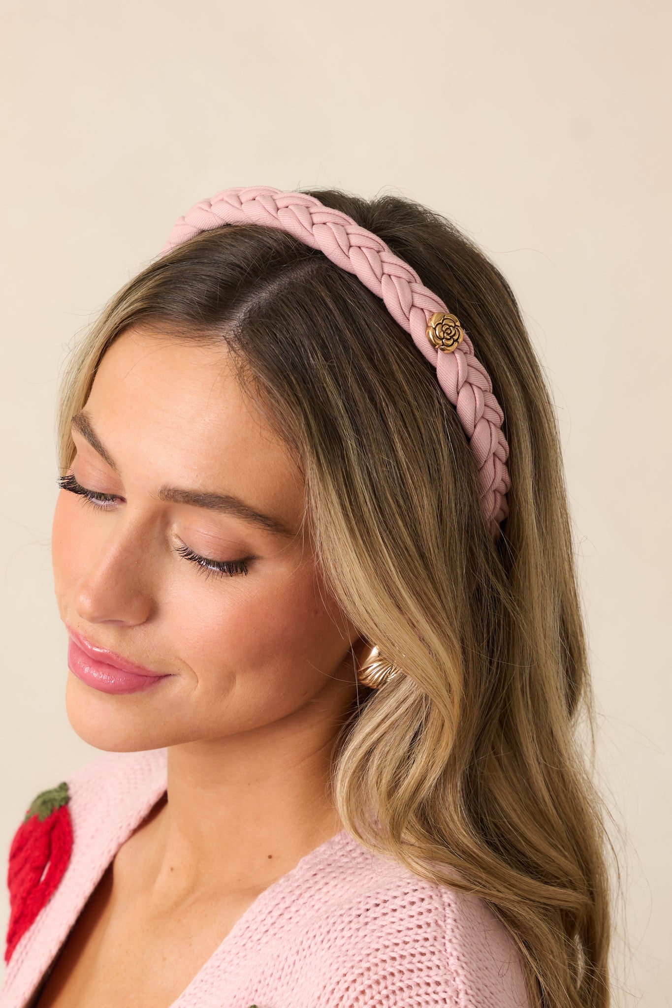 A closer look at the braided cloth design, emphasizing the texture and craftsmanship of the headband and its golden rose accents.