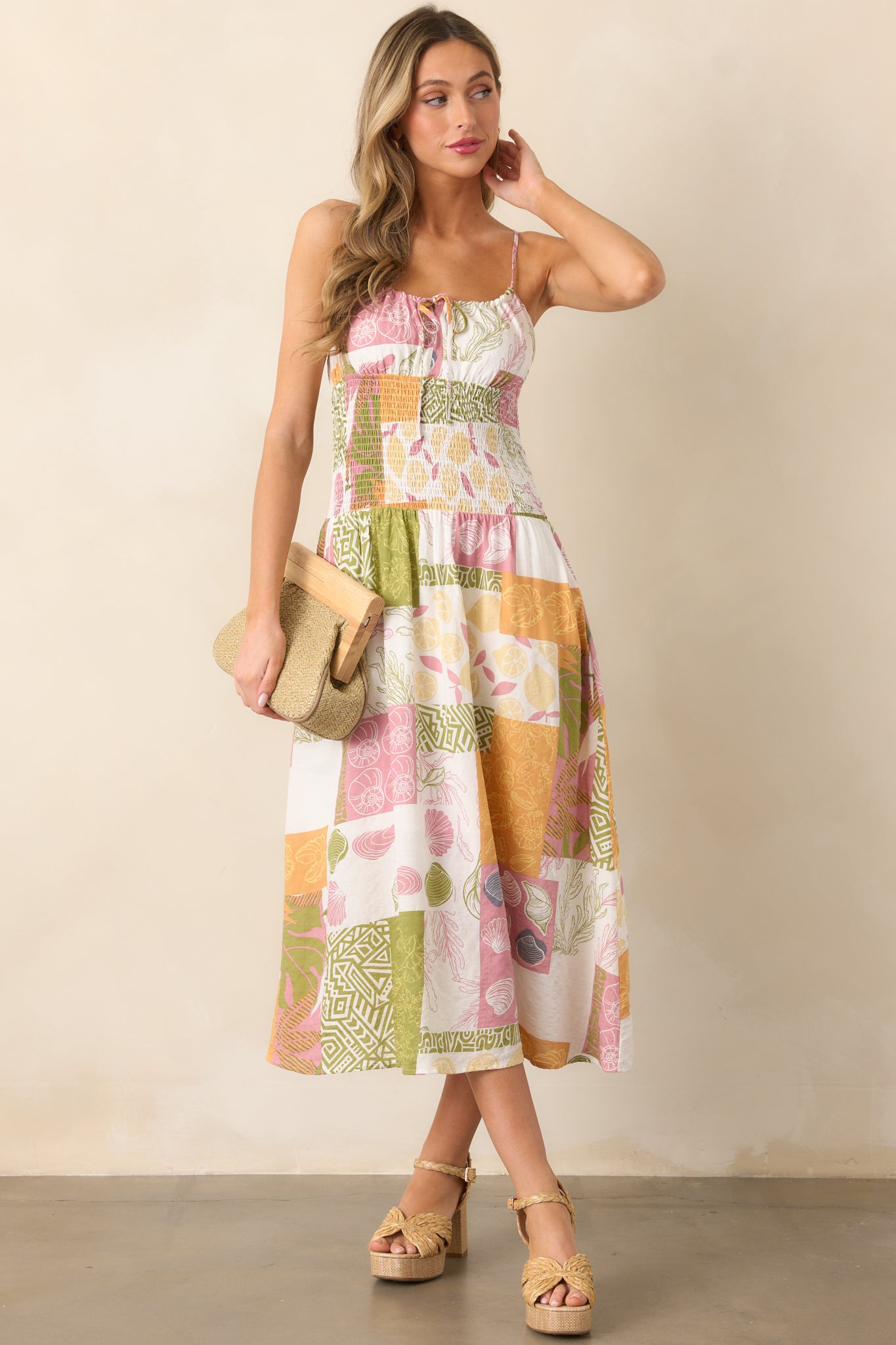 Ivory midi dress with a self-tie neckline and adjustable spaghetti straps, featuring a vibrant tropical patchwork design.