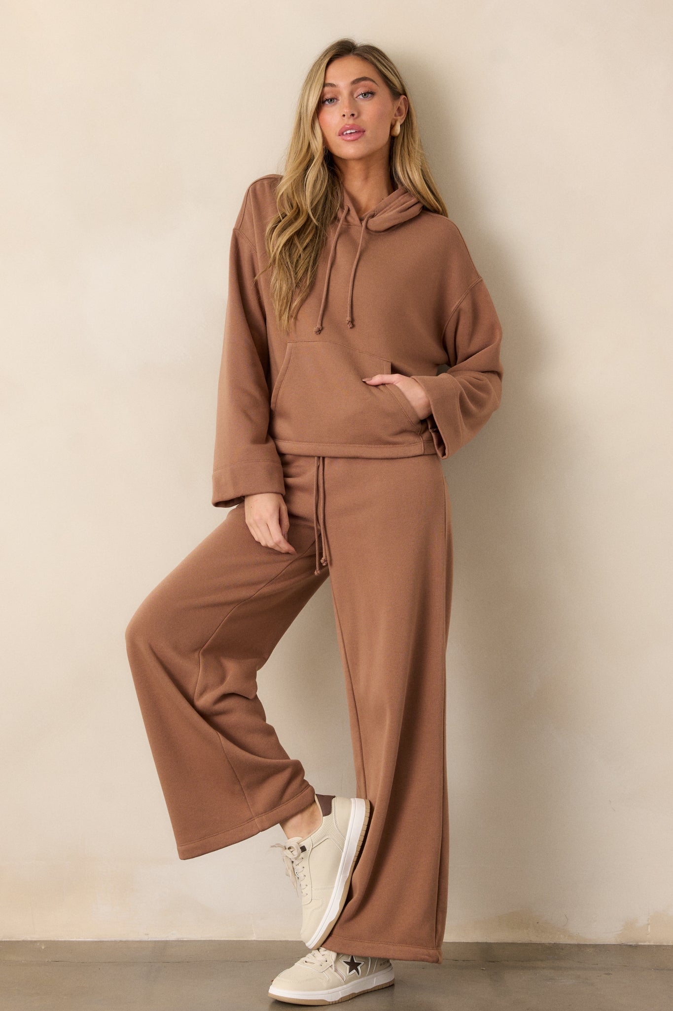 Brown sweatpants with a wide-leg fit, featuring an elastic waistband and adjustable drawstring.