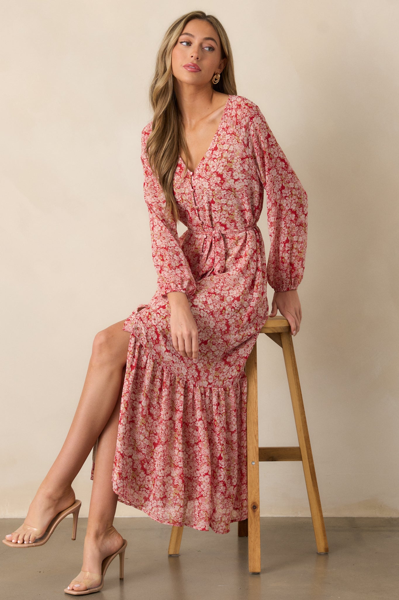 Side view of the cranberry dress, showcasing the flowy tiered skirt, button front, long sleeves, and the self-tie waistband cinching at the waist.