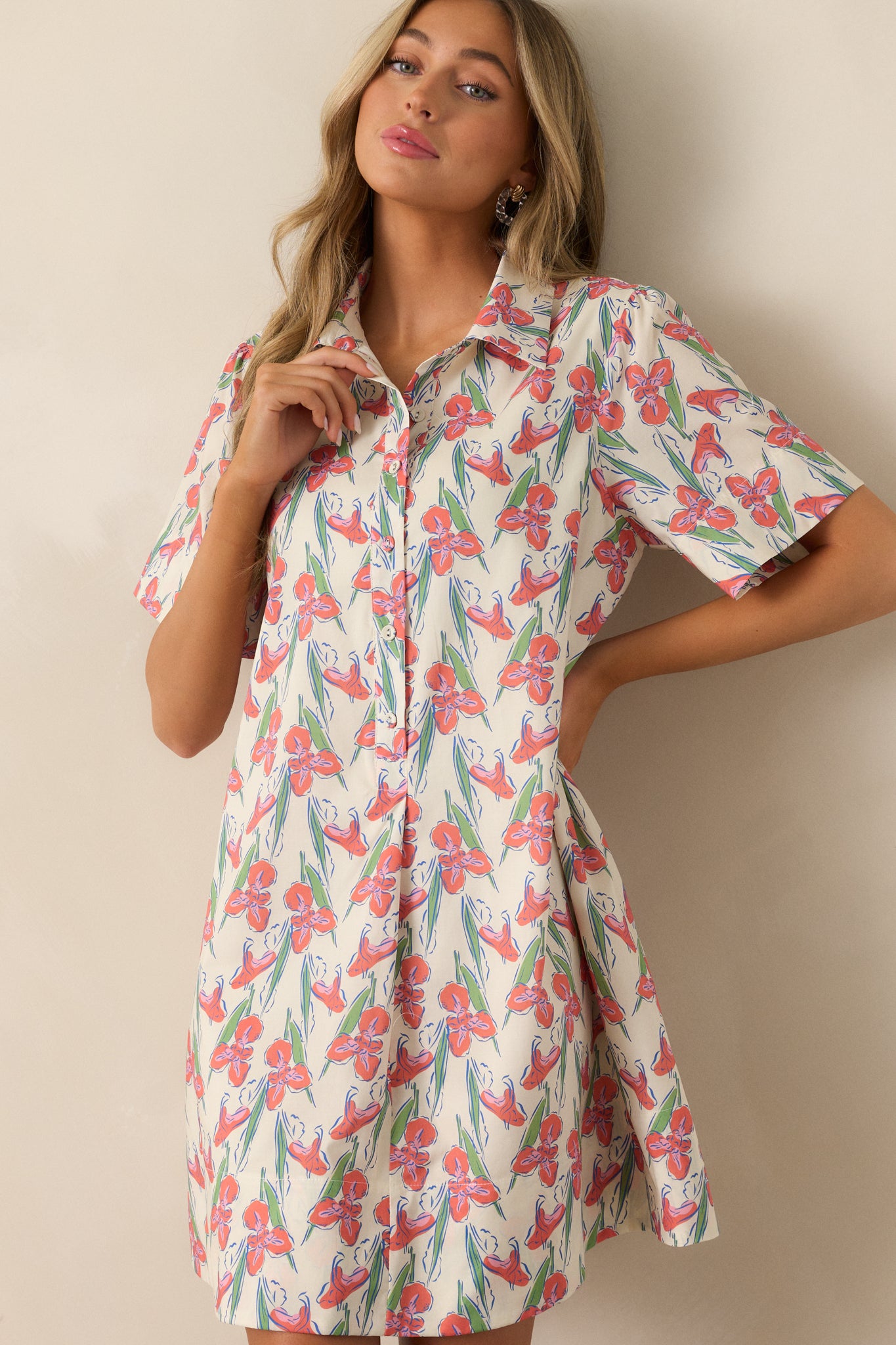 A cropped view of the orange dress's v-neckline and collar, highlighting the delicate floral print.