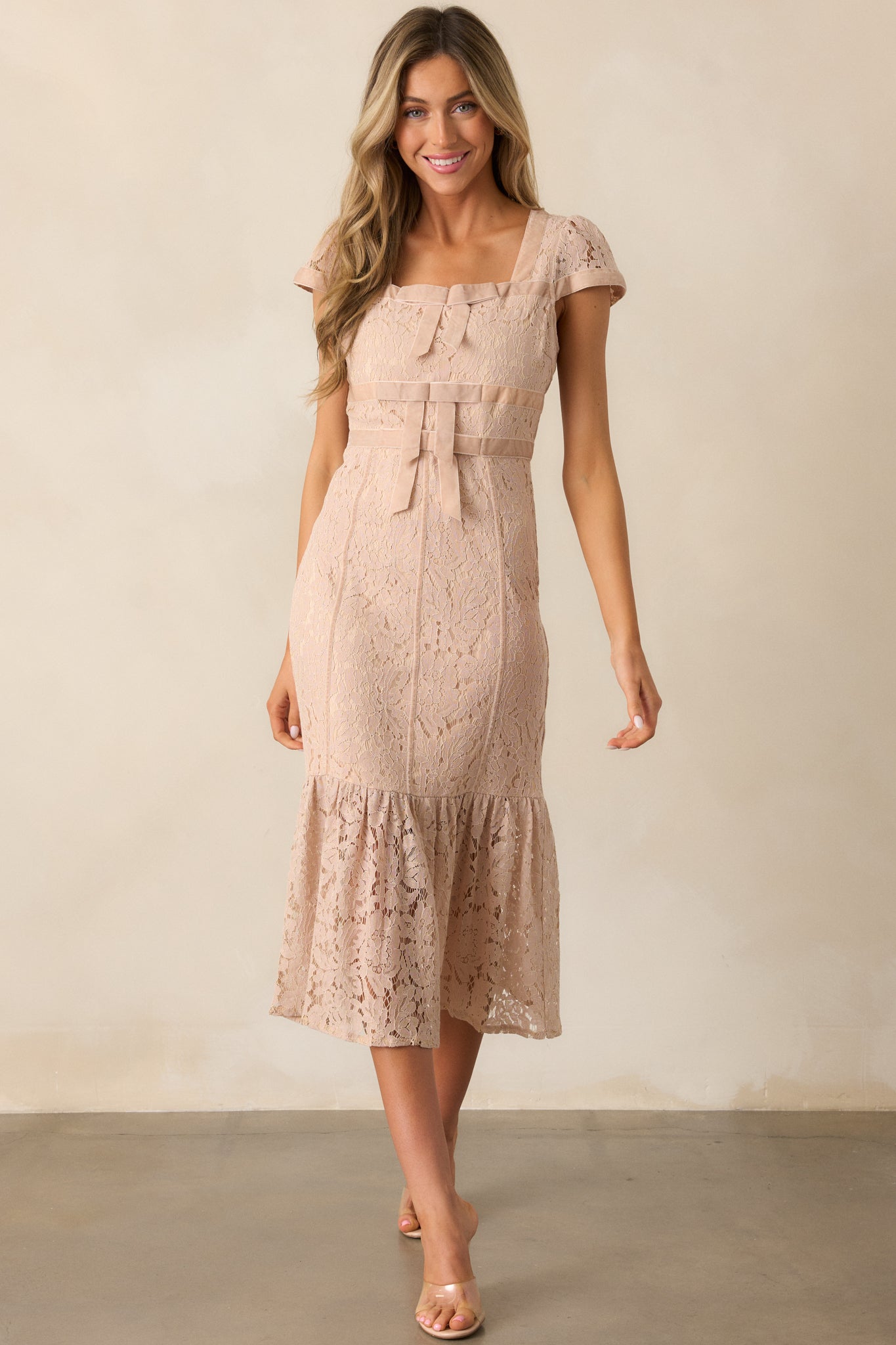 Romantic blush midi dress with a square neckline, delicate lace fabric, and a soft tiered bottom for an elegant flow.