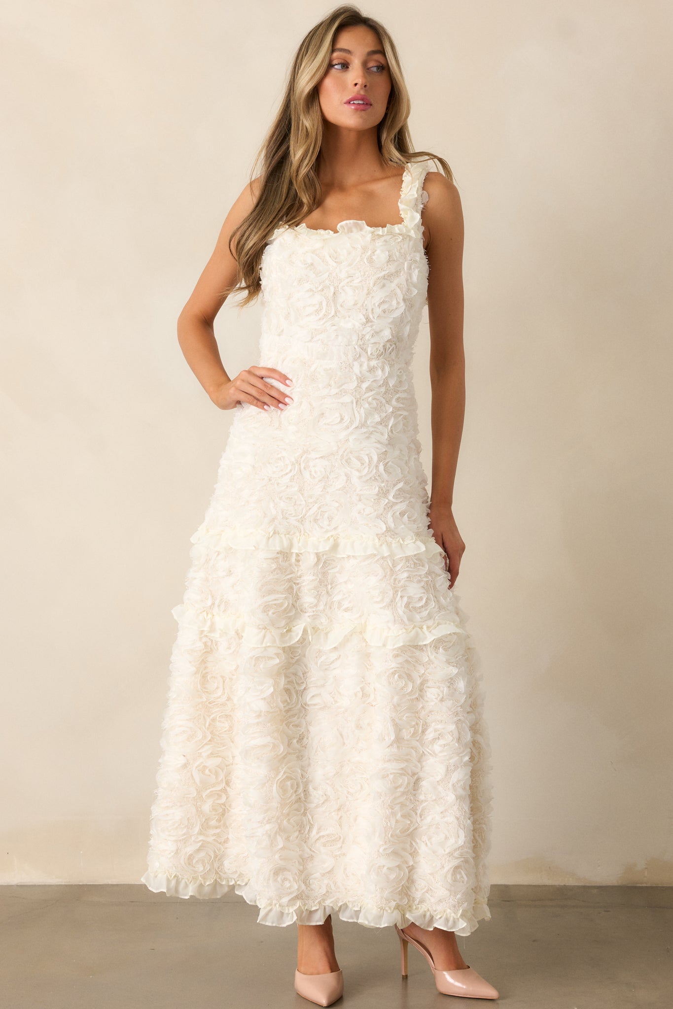 A full view of the ivory dress showcasing the square neckline, floral appliques, and tiered ruffle skirt detailing.