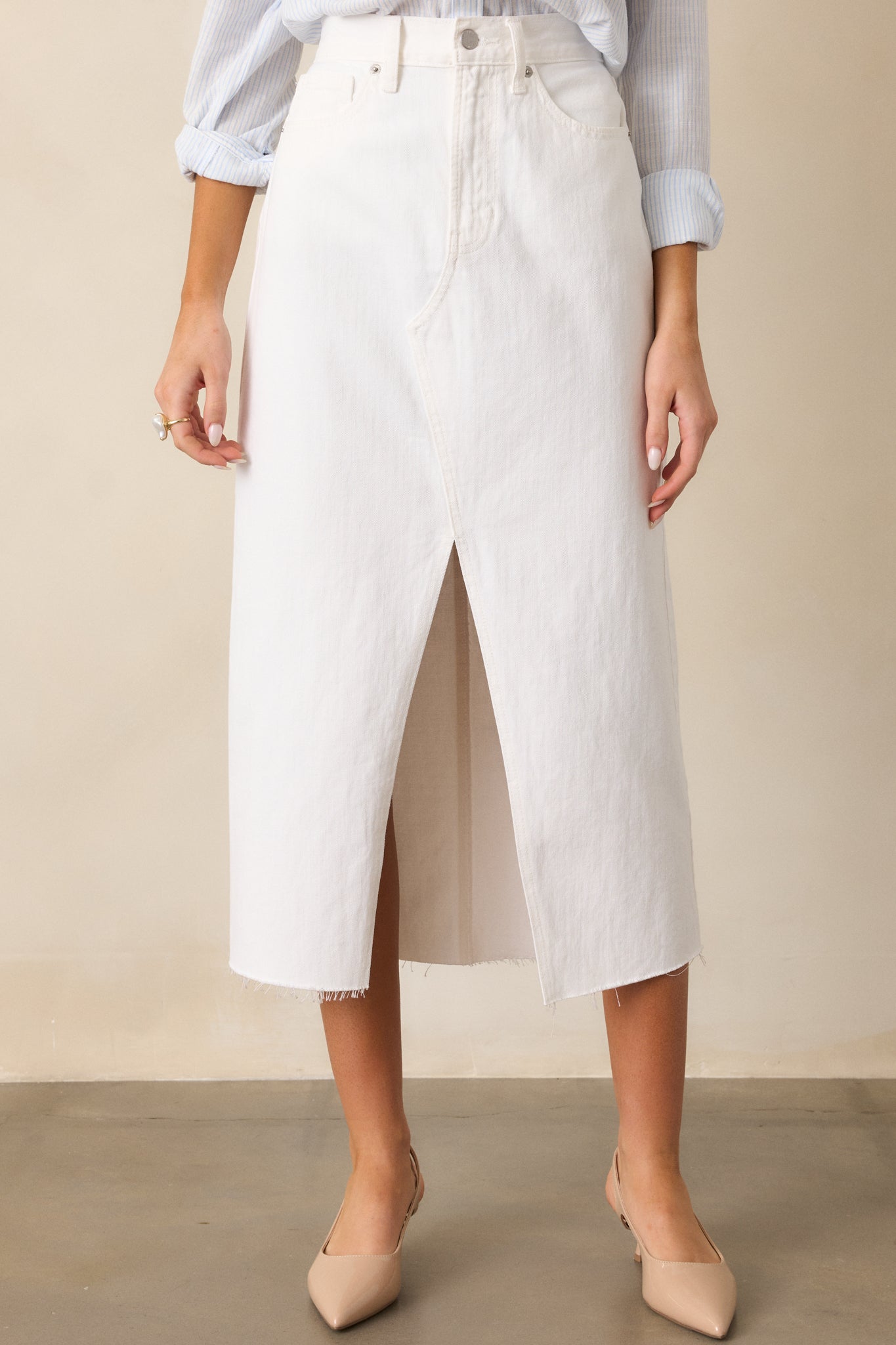 close view of the white skirt highlighting the front slit, functional belt loops, and smooth fabric.
