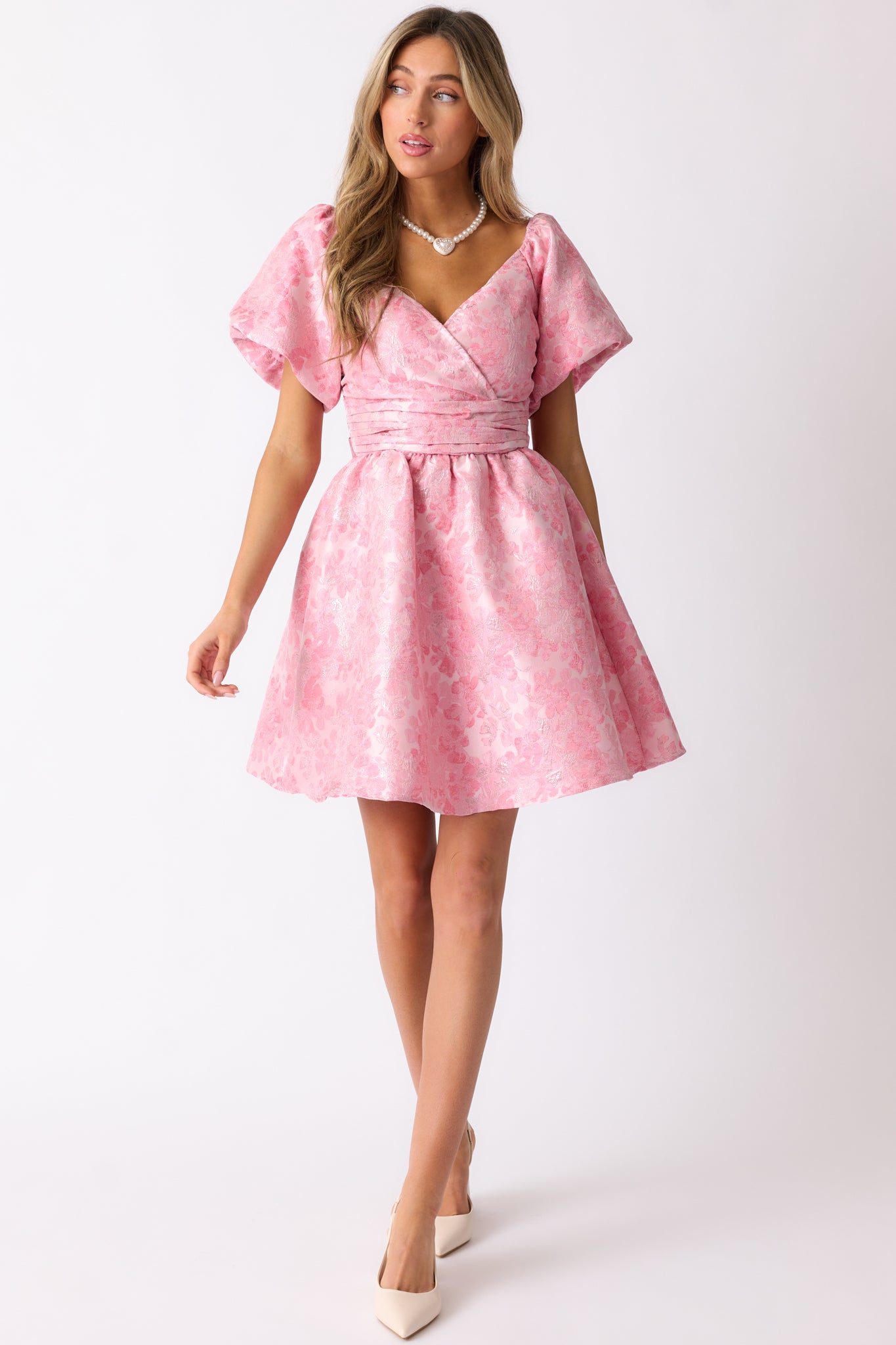 Another front shot of the pink dress, highlighting the self-tie pleated waistband and the flattering mini-length silhouette.