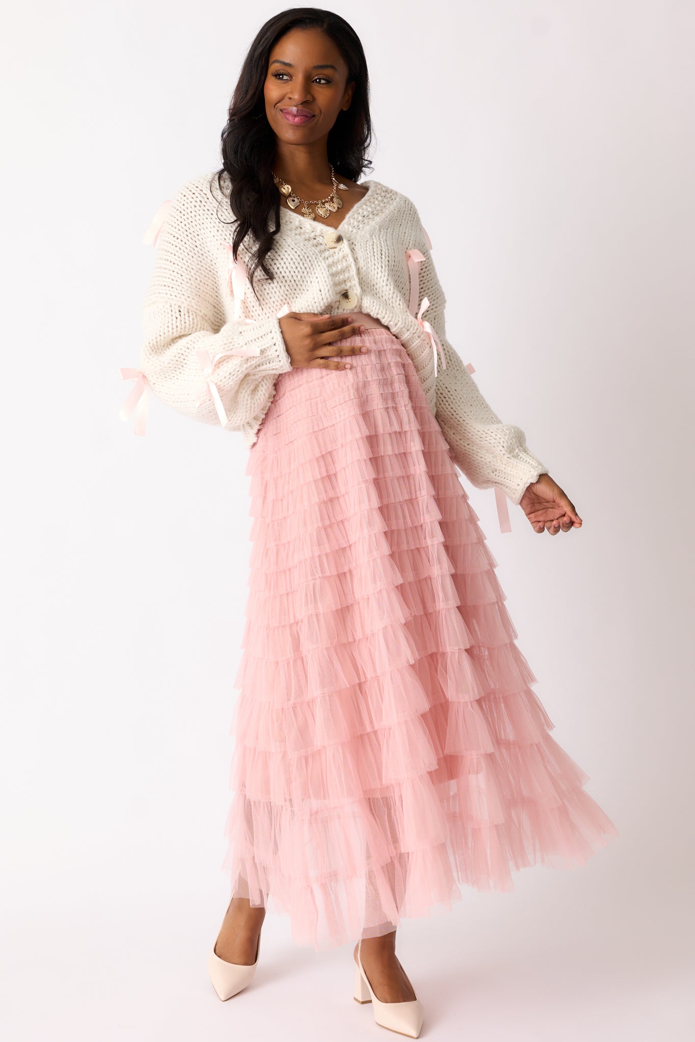 Full body view of a dusty pink skirt with an elastic waistband and a flowing, tiered tulle design reaching maxi length.