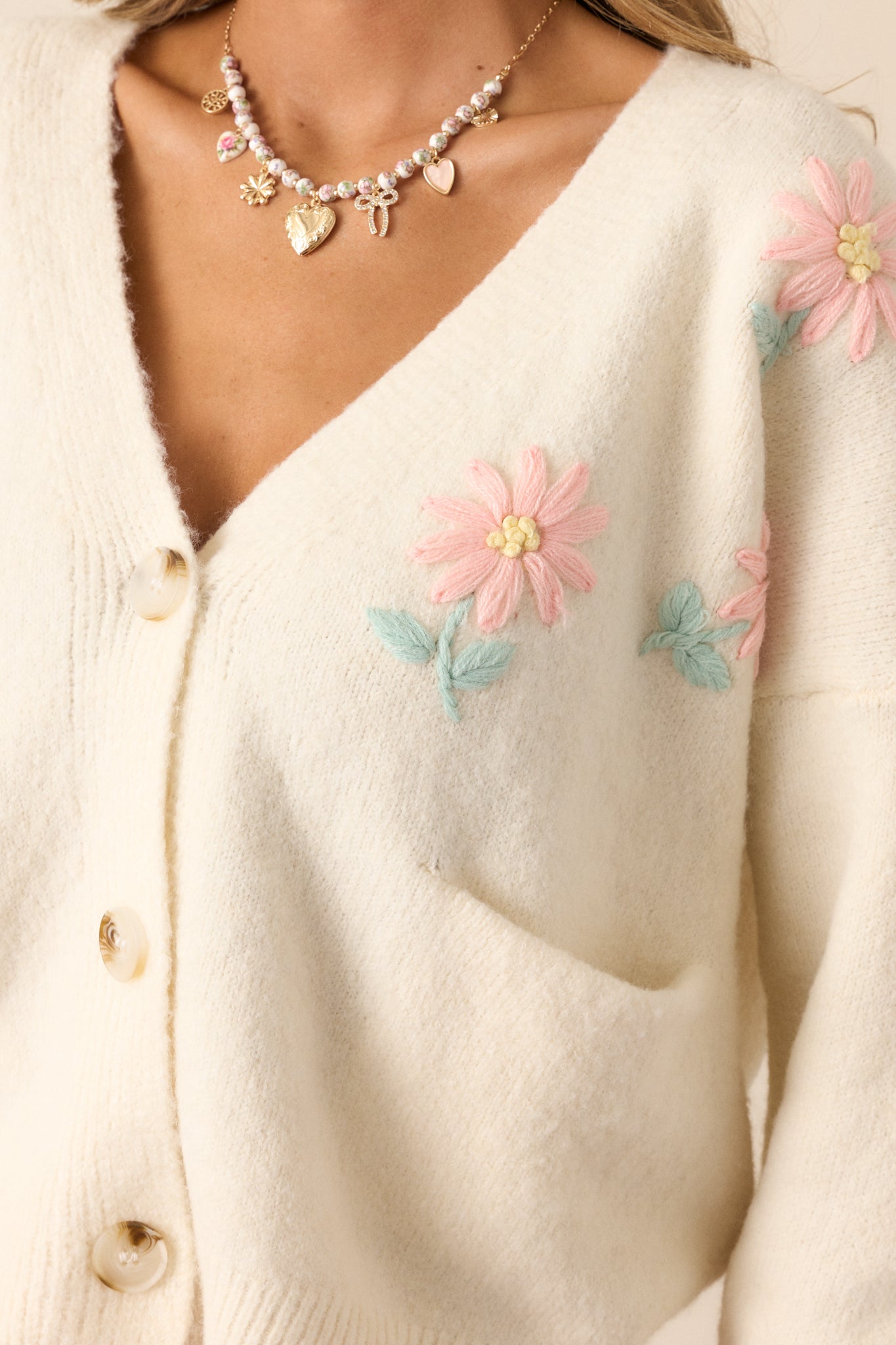 A zoomed-in shot of the embroidered floral print, highlighting the intricate stitching and soft pink and green colors.