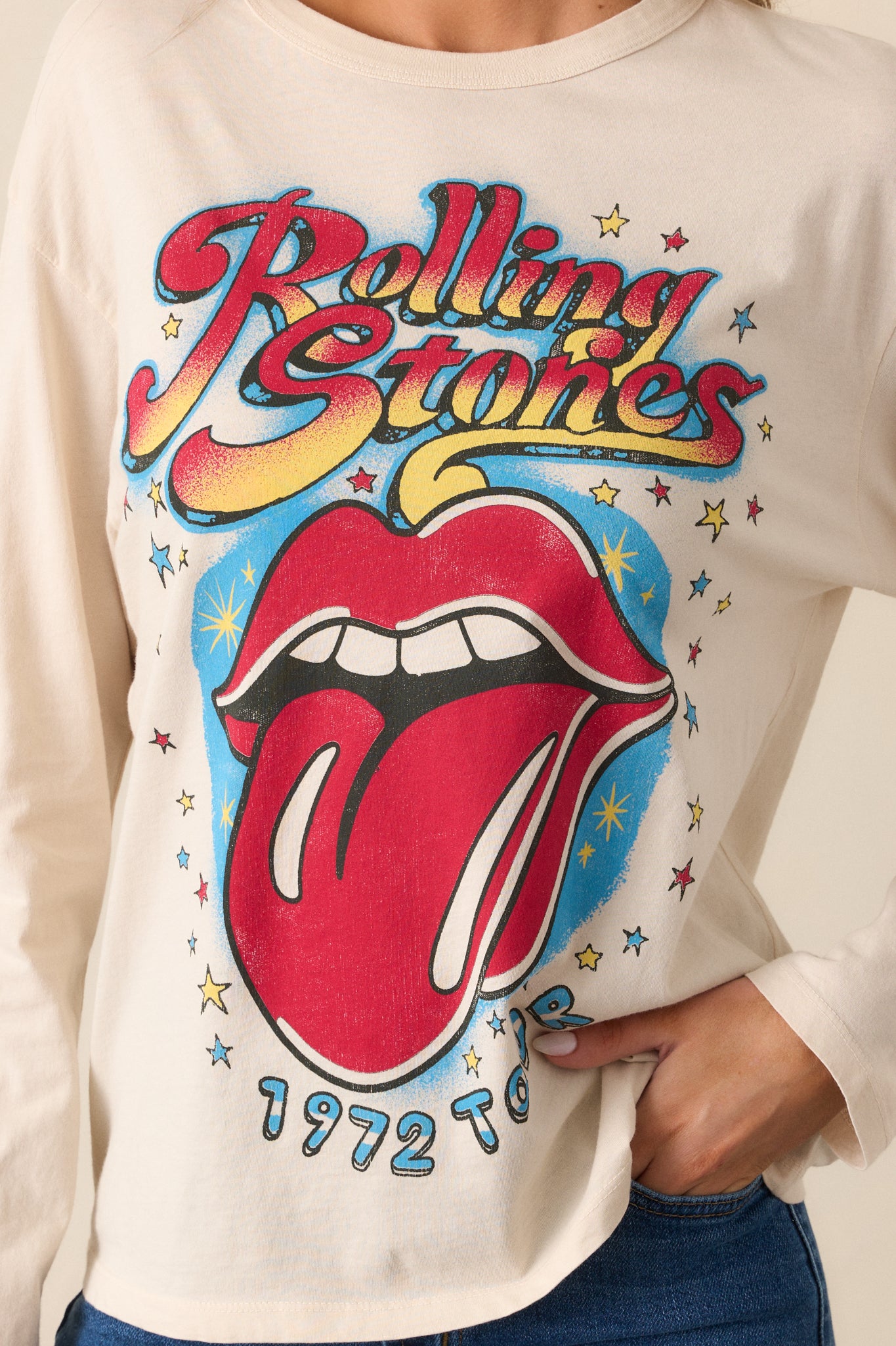 A close-up of the Rolling Stones 1972 Tour graphic on the front of the ecru tee, showcasing the vibrant colors and bold lettering.