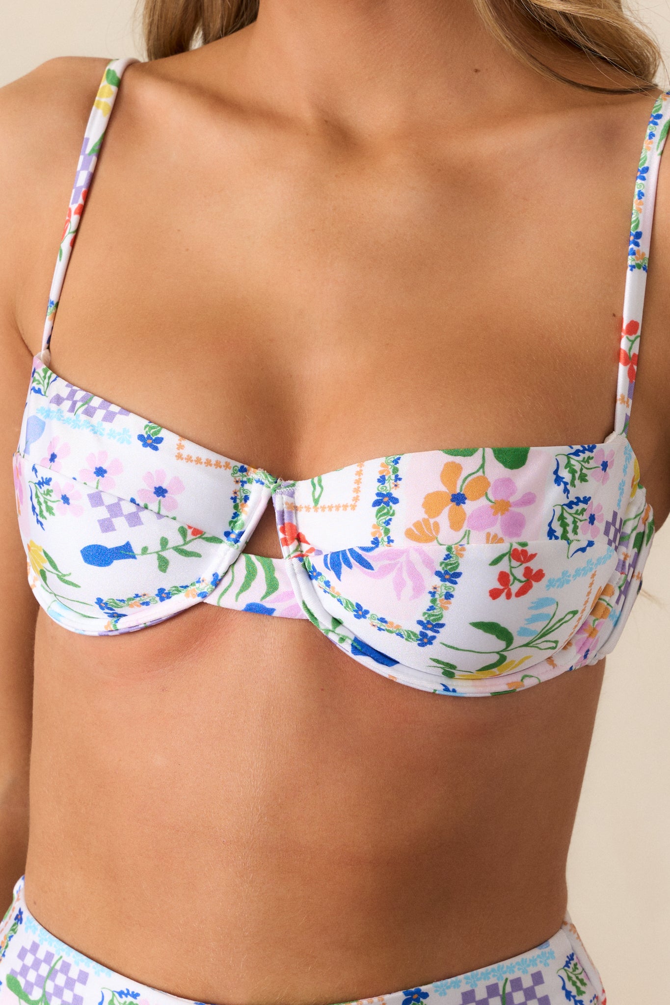 An up-close detail shot of the picnic print fabric on the ivory bikini top.