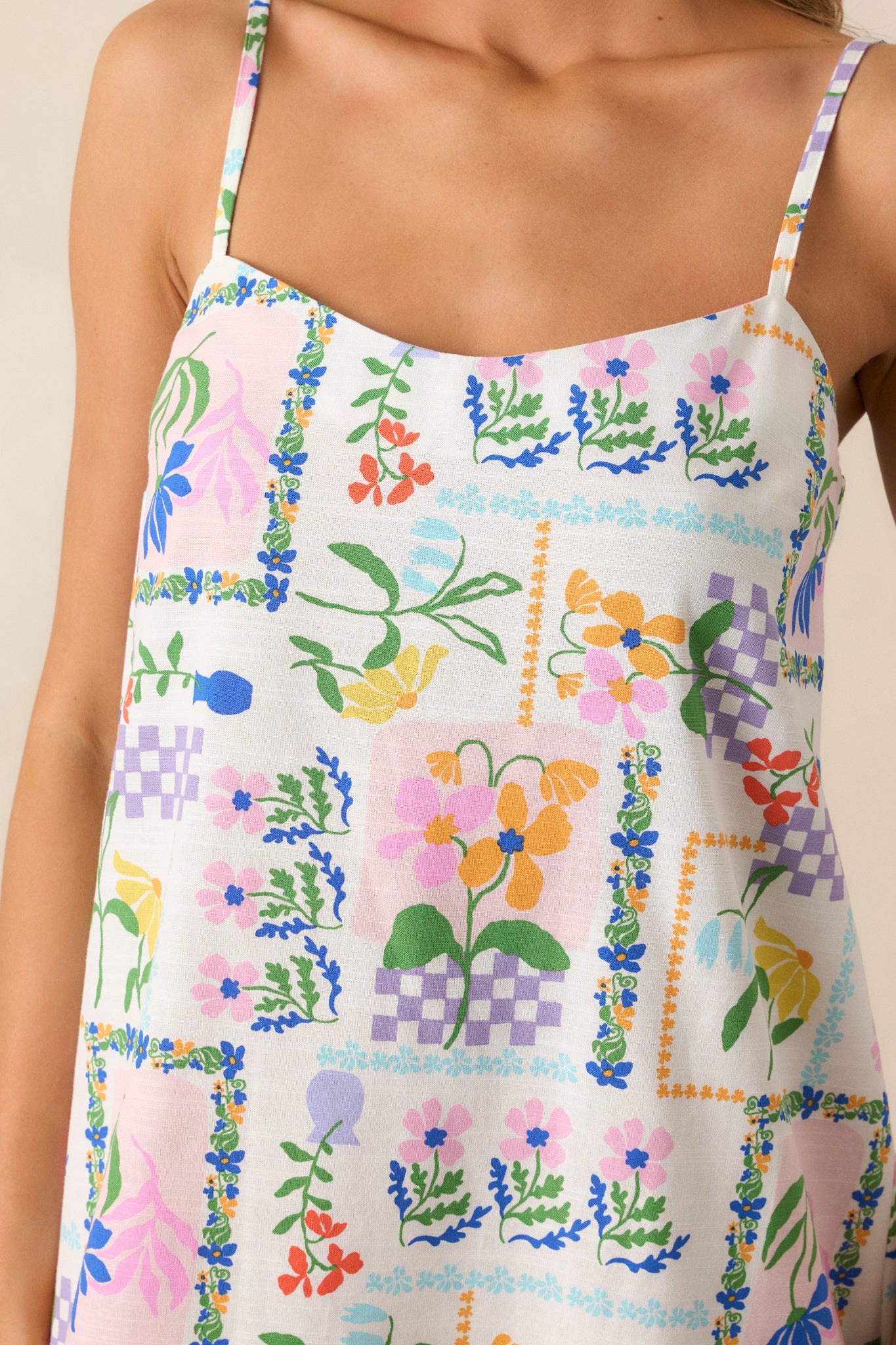 An up-close detail shot of the picnic print on the ivory mini dress, highlighting its vibrant colors and pattern.