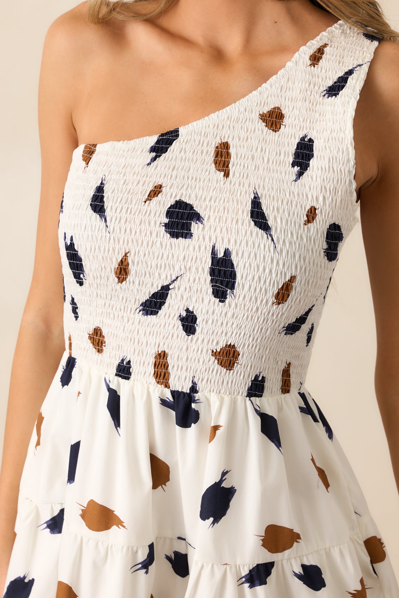 Close-up detail of the ivory fabric displaying the brown and navy brush print and ricrac hem texture.