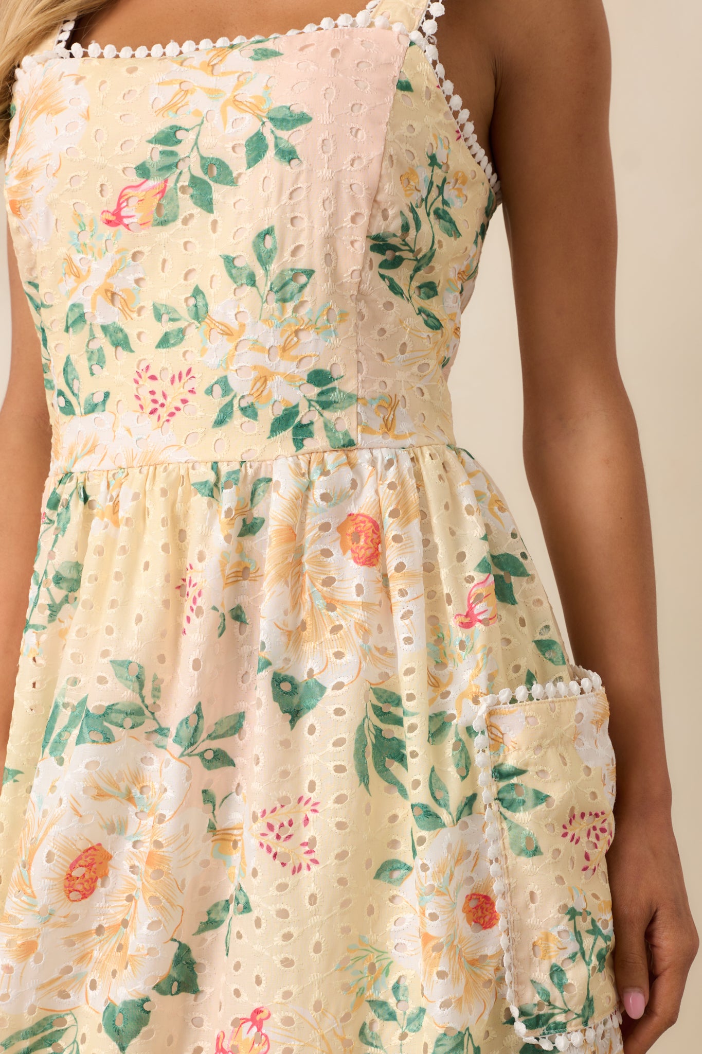 A detailed view of the floral embroidery, showcasing the intricate stitching and vibrant design of the yellow dress.