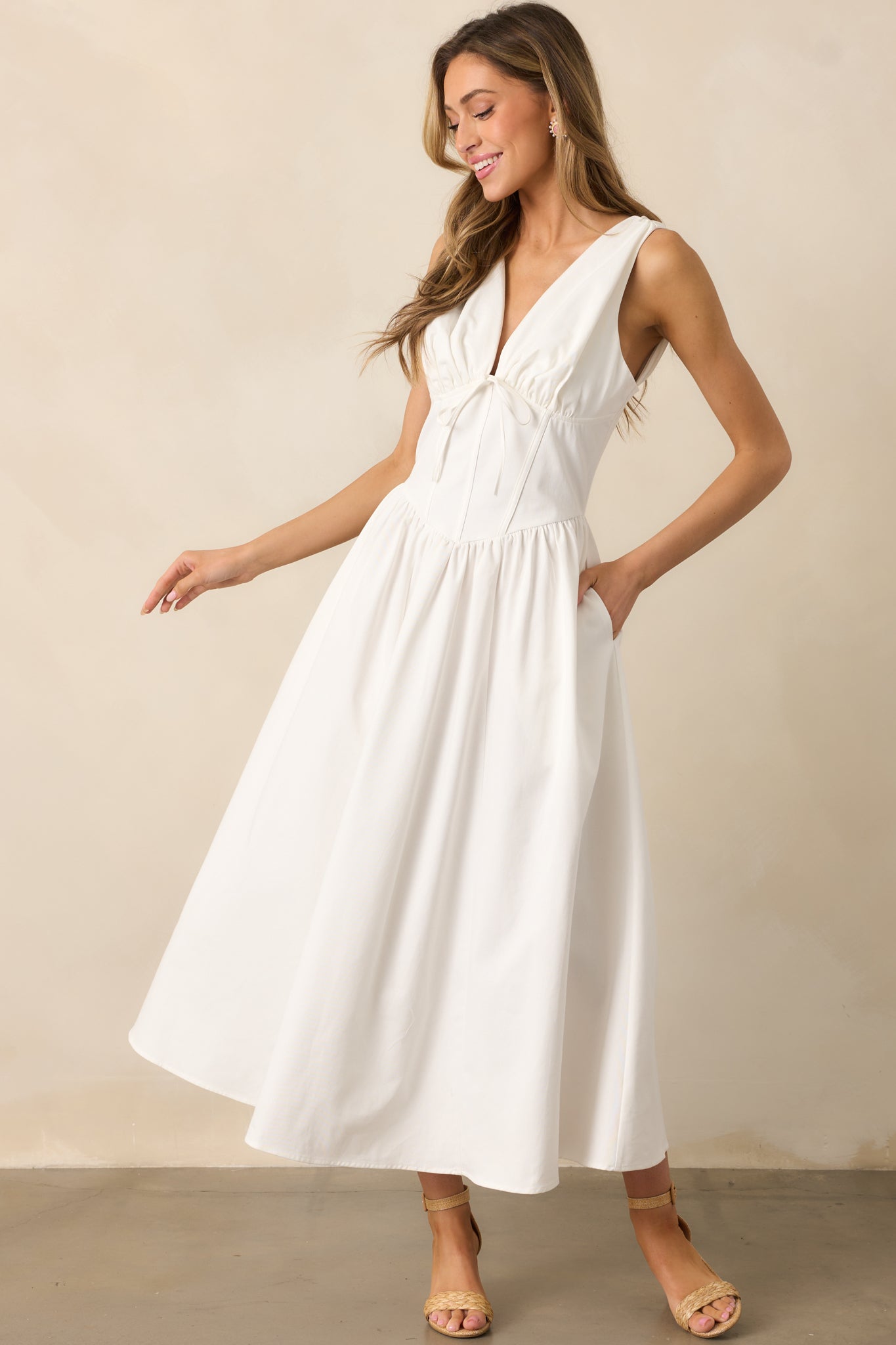 Elegant white dress with a corset waist and a flattering V-waistline for a structured yet feminine silhouette.