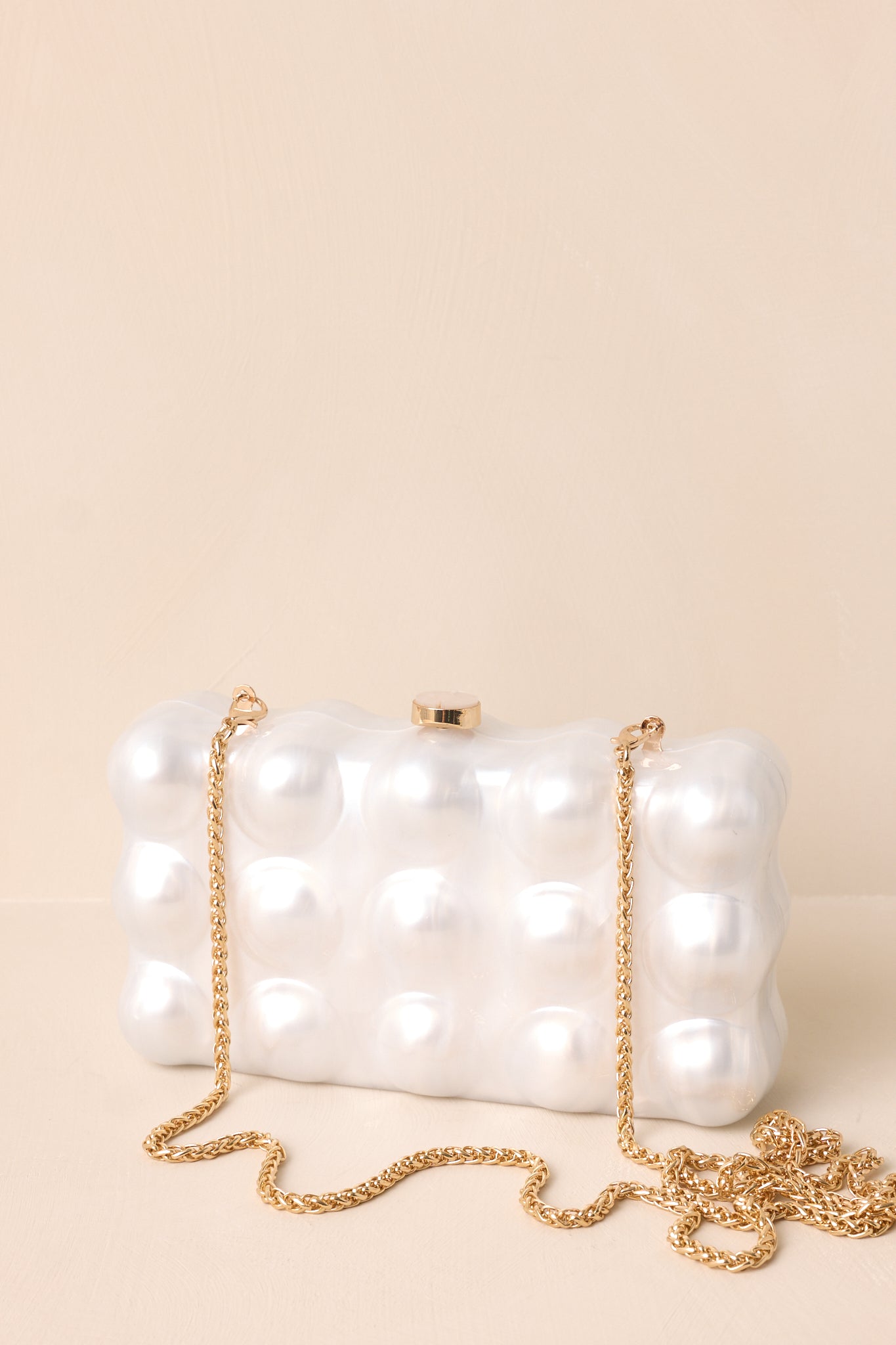 Chic rectangular clutch with a pearl-inspired bubble texture, adorned with a gold chain strap and a metallic clasp.