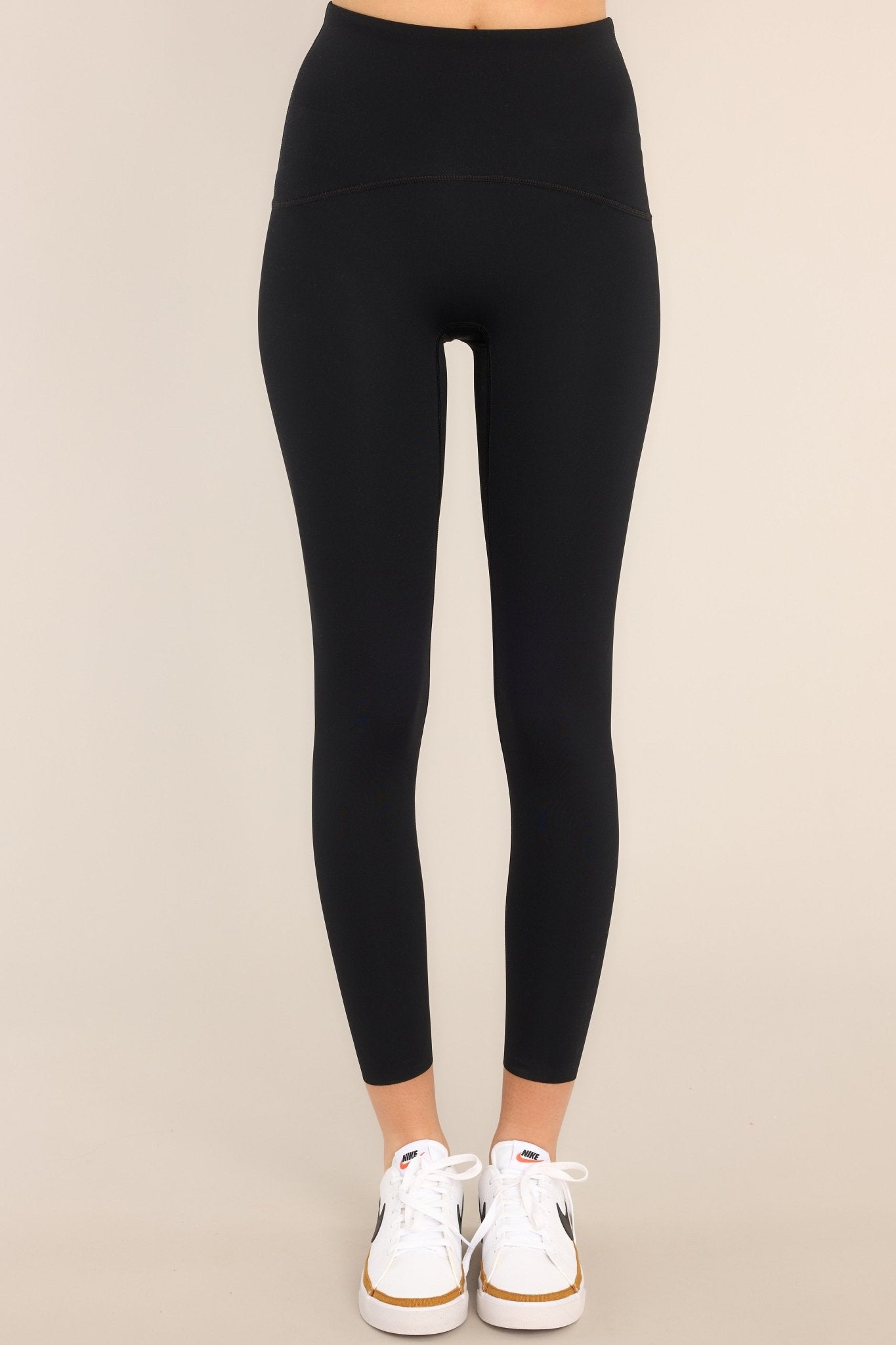 Front view of black leggings featuring a 7/8 length, high-rise contoured waistband, and a hidden pocket.